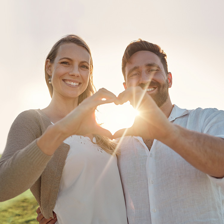 Happy couple making heart shape